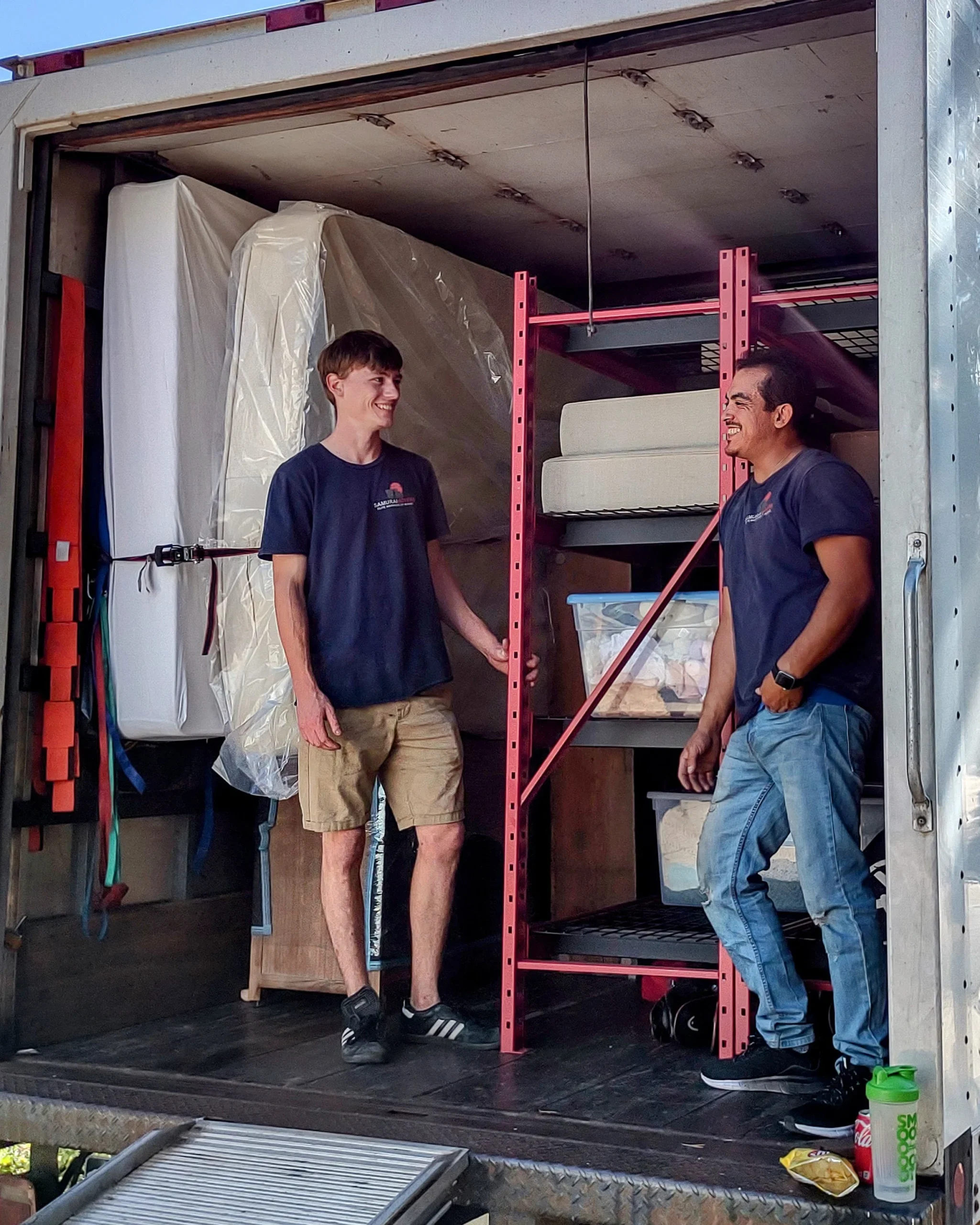 Two movers loading furniture into a moving truck for a professional move.