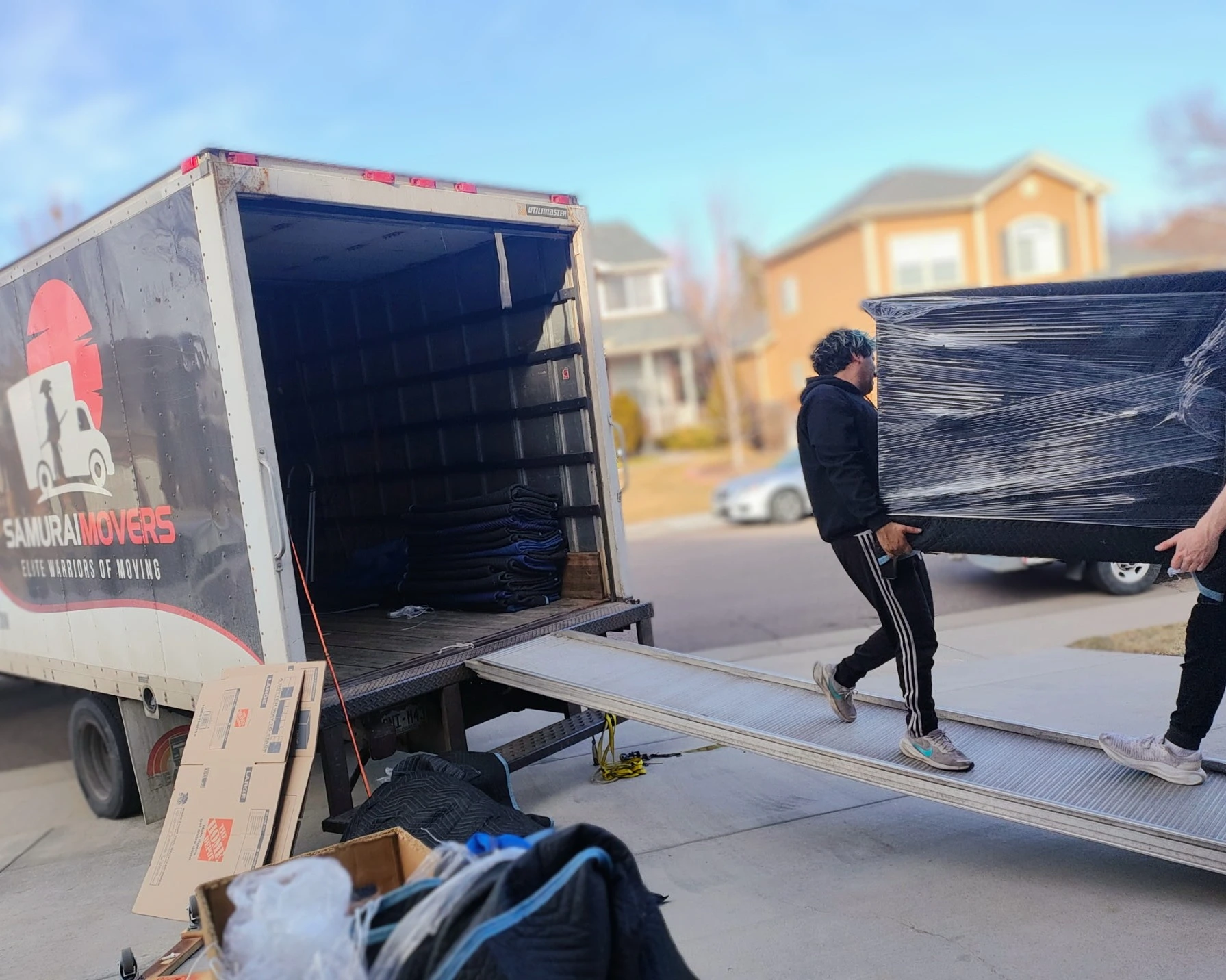 Movers loading large furniture onto a truck for a residential move.